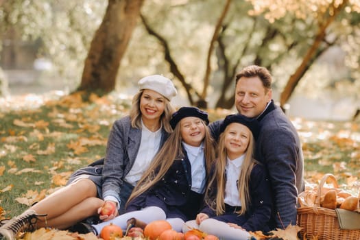 A big family on a picnic in the fall in a nature park. Happy people in the autumn park.