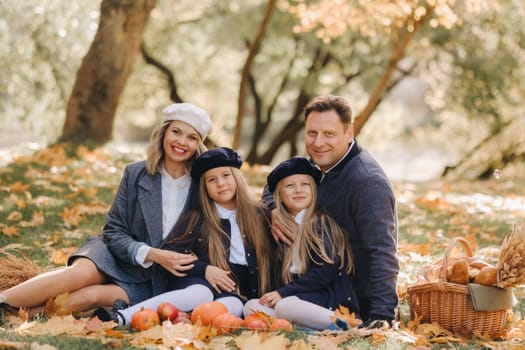 A big family on a picnic in the fall in a nature park. Happy people in the autumn park.