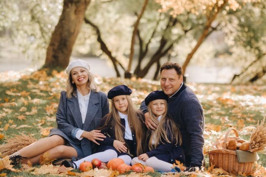 A big family on a picnic in the fall in a nature park. Happy people in the autumn park.