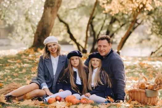 A big family on a picnic in the fall in a nature park. Happy people in the autumn park.