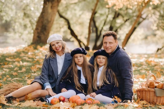 A big family on a picnic in the fall in a nature park. Happy people in the autumn park.