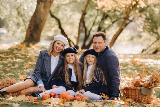 A big family on a picnic in the fall in a nature park. Happy people in the autumn park.