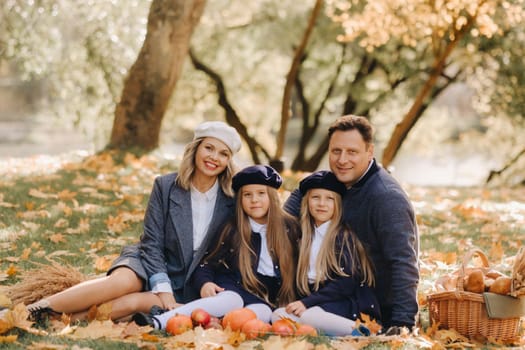 A big family on a picnic in the fall in a nature park. Happy people in the autumn park.