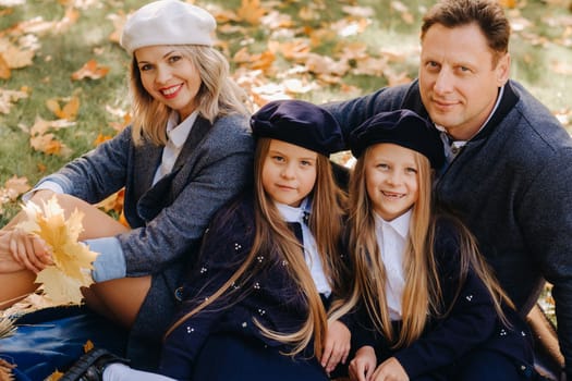 A big family on a picnic in the fall in a nature park. Happy people in the autumn park.