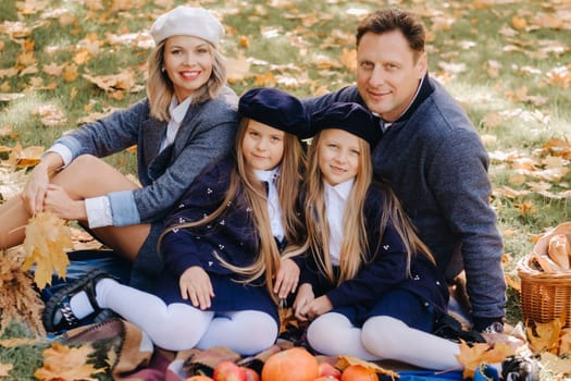 A big family on a picnic in the fall in a nature park. Happy people in the autumn park.