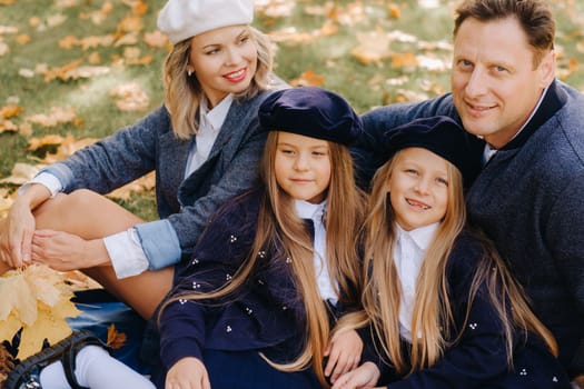 A big family on a picnic in the fall in a nature park. Happy people in the autumn park.