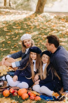 A big family on a picnic in the fall in a nature park. Happy people in the autumn park.