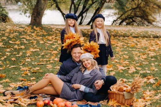 A big family on a picnic in the fall in a nature park. Happy people in the autumn park.