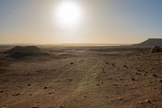 Landscape scenic view of desolate barren rocky western desert in Egypt with mountains at sunrise