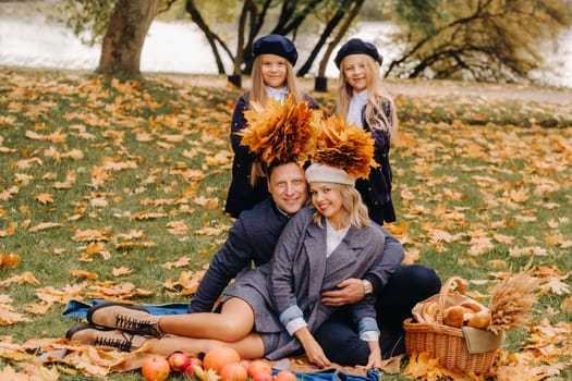 A big family on a picnic in the fall in a nature park. Happy people in the autumn park.