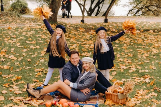 A big family on a picnic in the fall in a nature park. Happy people in the autumn park.