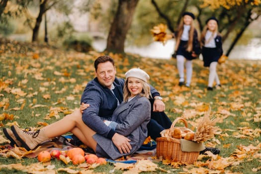 A big family on a picnic in the fall in a nature park. Happy people in the autumn park.