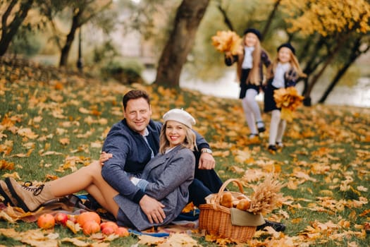 A big family on a picnic in the fall in a nature park. Happy people in the autumn park.