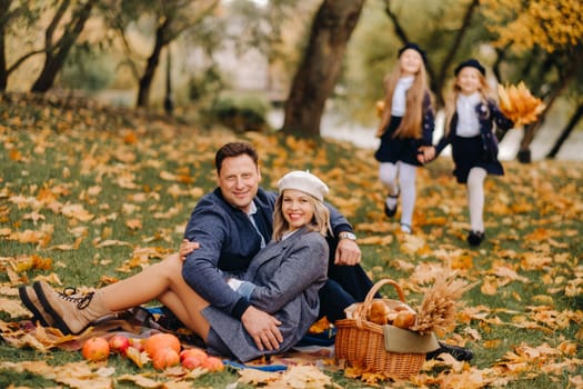 A big family on a picnic in the fall in a nature park. Happy people in the autumn park.