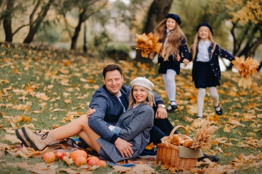 A big family on a picnic in the fall in a nature park. Happy people in the autumn park.