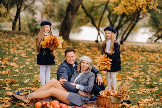 A big family on a picnic in the fall in a nature park. Happy people in the autumn park.