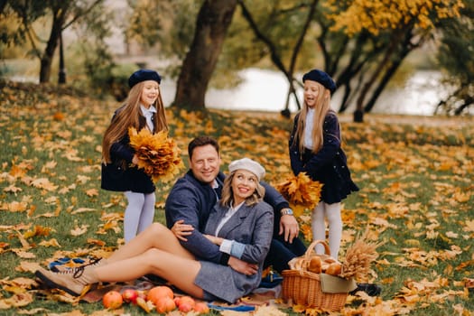 A big family on a picnic in the fall in a nature park. Happy people in the autumn park.