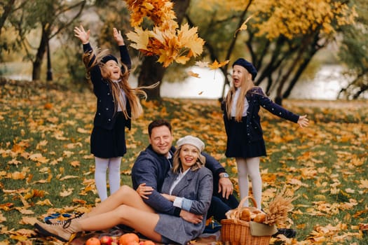 A big family on a picnic in the fall in a nature park. Happy people in the autumn park.