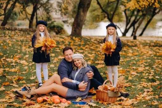 A big family on a picnic in the fall in a nature park. Happy people in the autumn park.