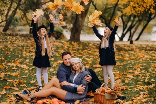 A big family on a picnic in the fall in a nature park. Happy people in the autumn park.