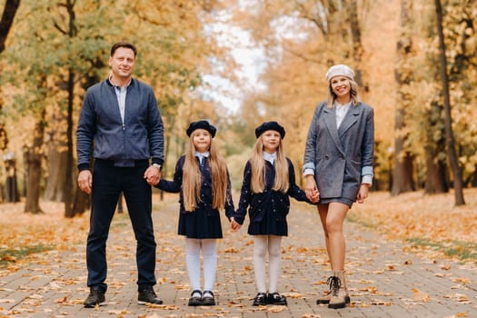 A large family walks in the park in the fall. Happy people in the autumn park.