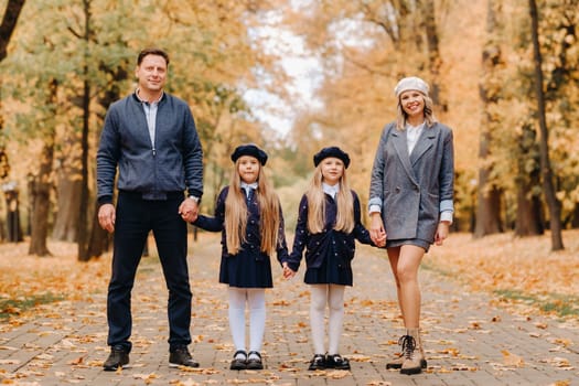 A large family walks in the park in the fall. Happy people in the autumn park.