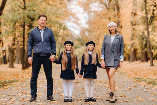 A large family walks in the park in the fall. Happy people in the autumn park.