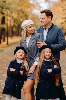 A large family walks in the park in the fall. Happy people in the autumn park.