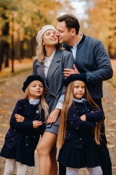 A large family walks in the park in the fall. Happy people in the autumn park.