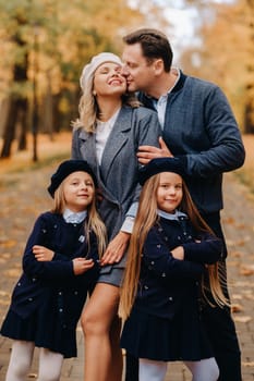 A large family walks in the park in the fall. Happy people in the autumn park.