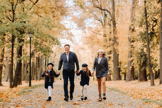 A large family walks in the park in the fall. Happy people in the autumn park.