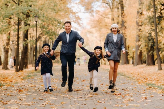 A large family walks in the park in the fall. Happy people in the autumn park.