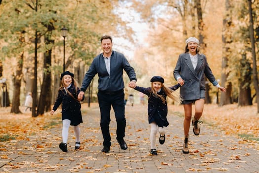 A large family walks in the park in the fall. Happy people in the autumn park.