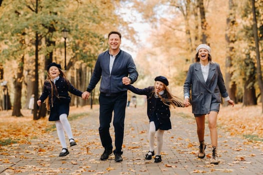 A large family walks in the park in the fall. Happy people in the autumn park.