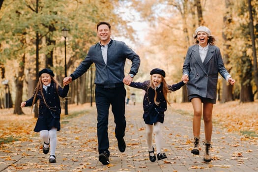 A large family walks in the park in the fall. Happy people in the autumn park.