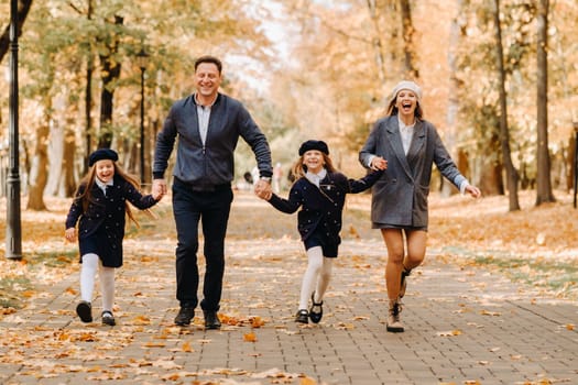 A large family walks in the park in the fall. Happy people in the autumn park.