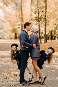 A large family walks in the park in the fall. Happy people in the autumn park.