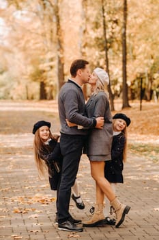 A large family walks in the park in the fall. Happy people in the autumn park.