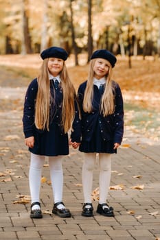 Happy children holding hands in a beautiful autumn park.