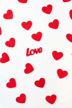 The background which consists of red hearts, the inscription love in the middle of the hearts. Vertical photo. Love concept, greeting card for valentine's day