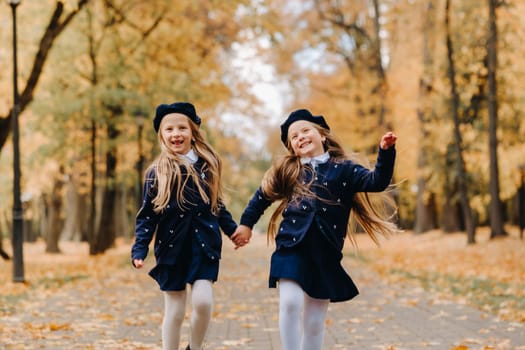 Happy children are running in a beautiful autumn park.