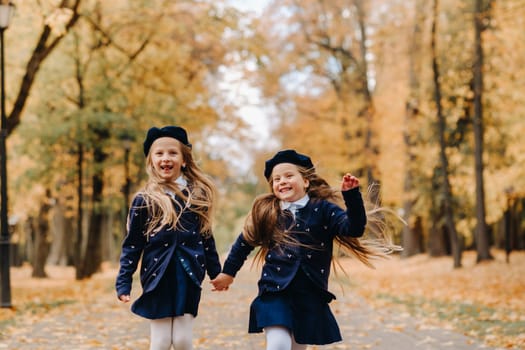 Happy children are running in a beautiful autumn park.