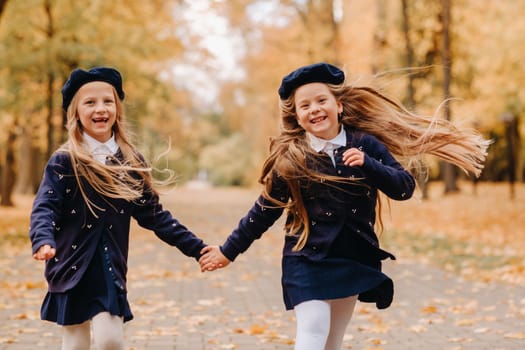 Happy children are running in a beautiful autumn park.