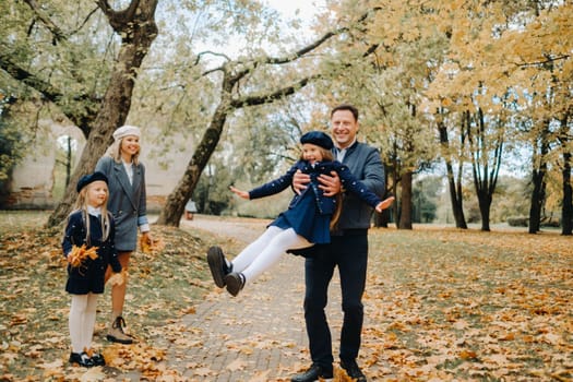 A large family walks in the park in the fall. Happy people in the autumn park.