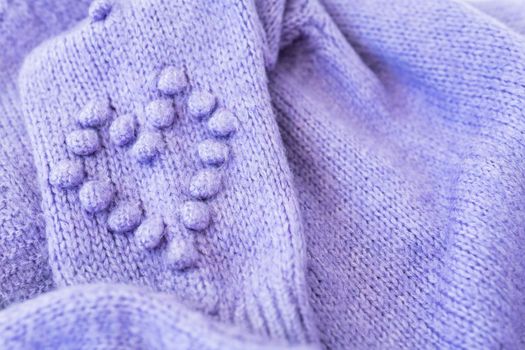 Background texture: lavender wool knitted fabric with a heart. Very peri, warm cozy sweater