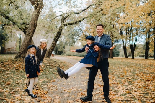 A large family walks in the park in the fall. Happy people in the autumn park.