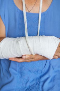 senior woman with a rewound arm in a cast and bandage. Blow, fracture, bones, hospital