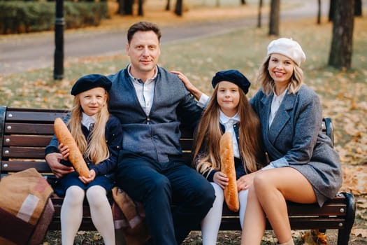 A large family is sitting on a bench in an autumn park. Happy people in the autumn park.