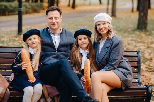 A large family is sitting on a bench in an autumn park. Happy people in the autumn park.