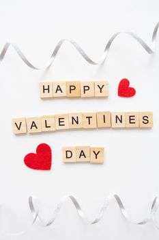 Postcard Happy Valentine's Day. Wooden lettering Happy Valentine's Day. The 14th of February. Festive ribbon